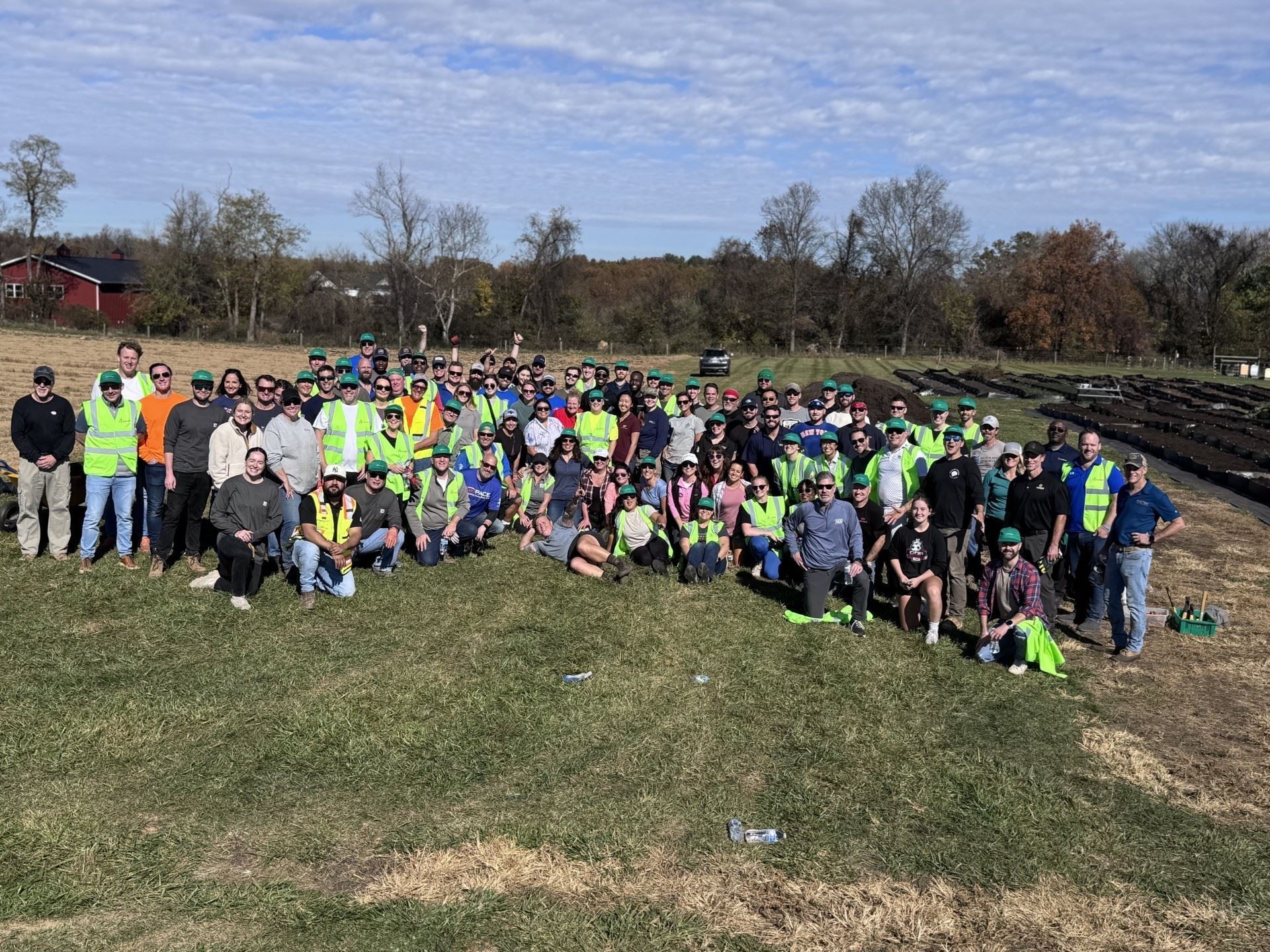 A large group of volunteers gathers at a community farm in the supplied DCAN photograph.